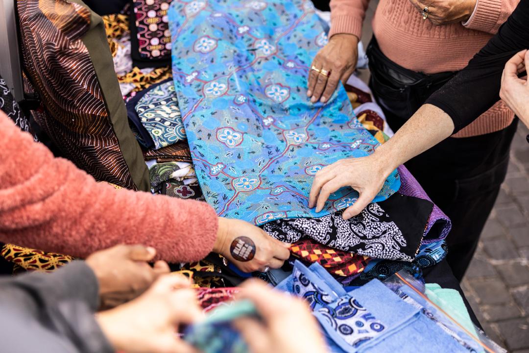 People touching different fabrics on a table
