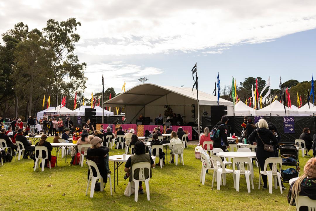 People sitting at an event held in a park