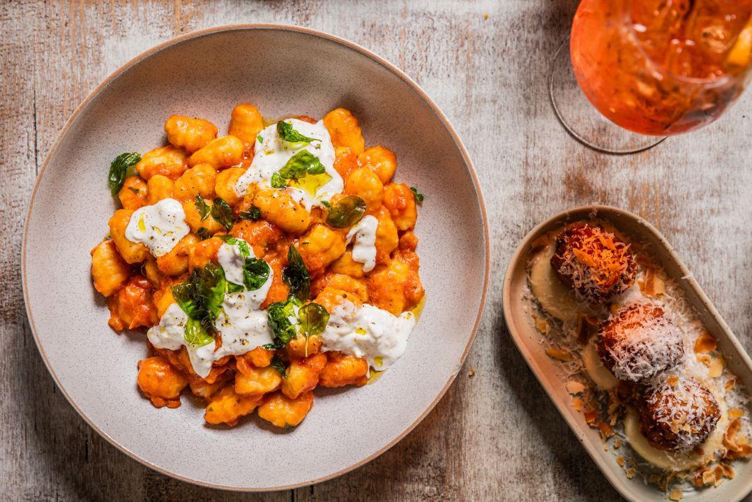 Delicious looking bowl of tomato creamy pasta with a side of meatballs