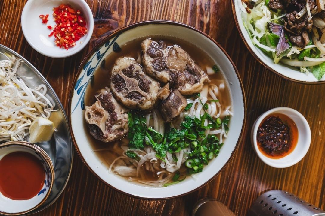 Bowl of pho with noodles and pieces of meat