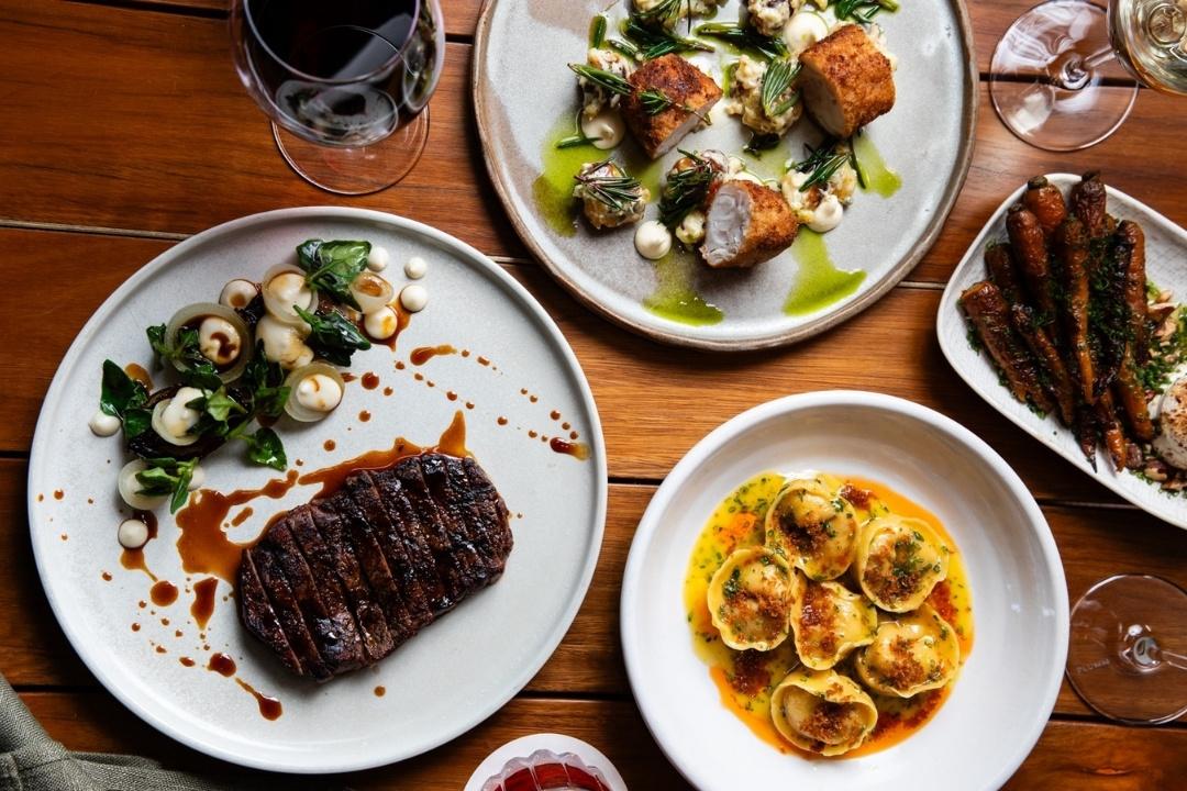 Plates of creamy pasta, steak and salad