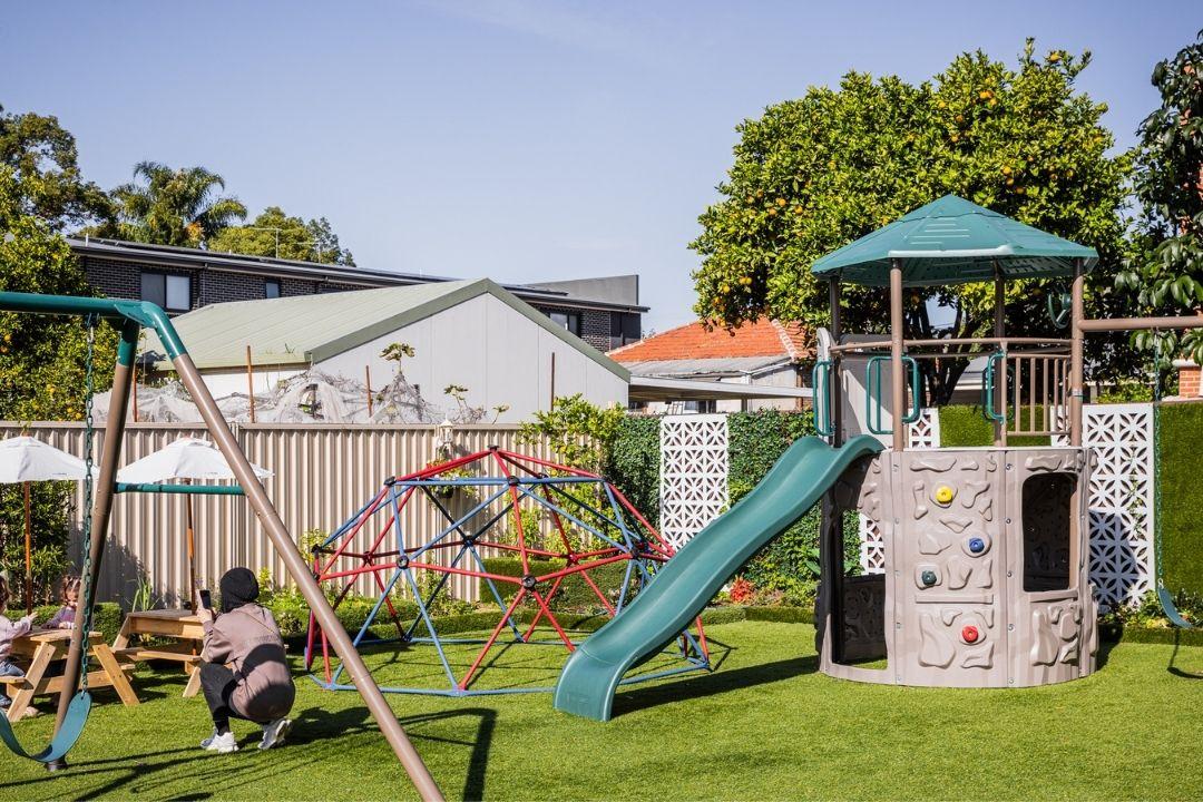 Slide and swing set in open backyard