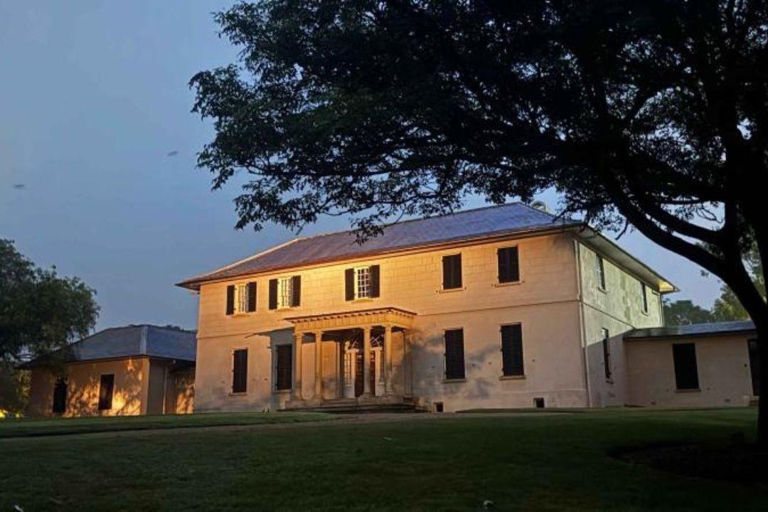 Large two story sandstone building at dusk