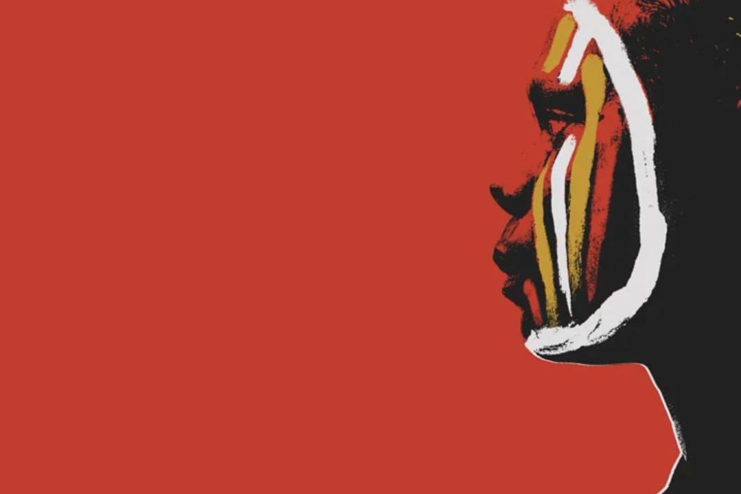 Red background with a face painted in yellow, red and mustard coloured lines