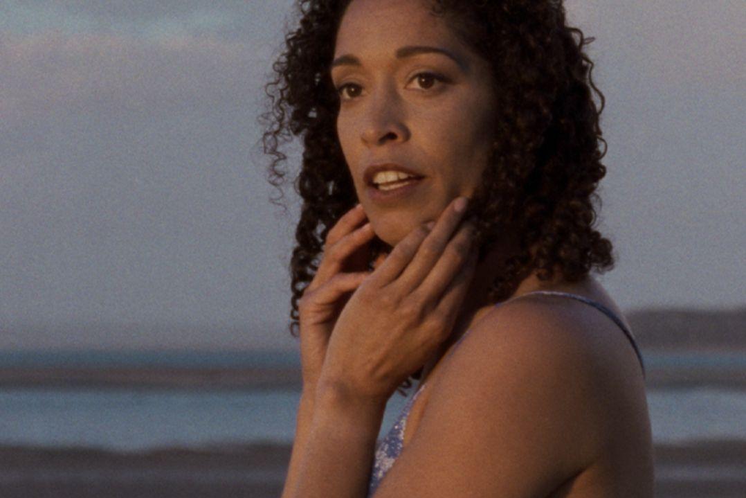 Woman with curly hair looking off into the distance