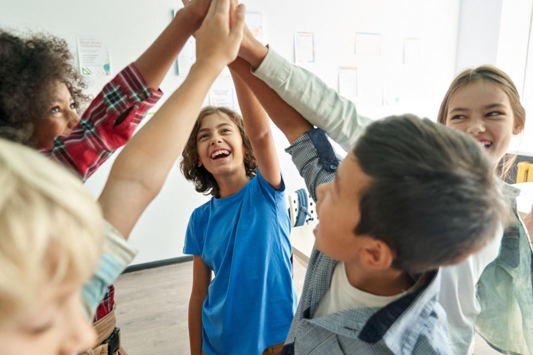 Kids smiling and high fiving each other