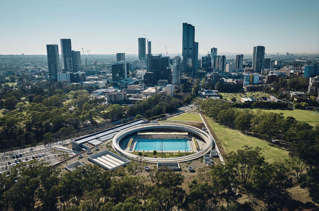 Aerial view of large round building with swimming pool in the middle