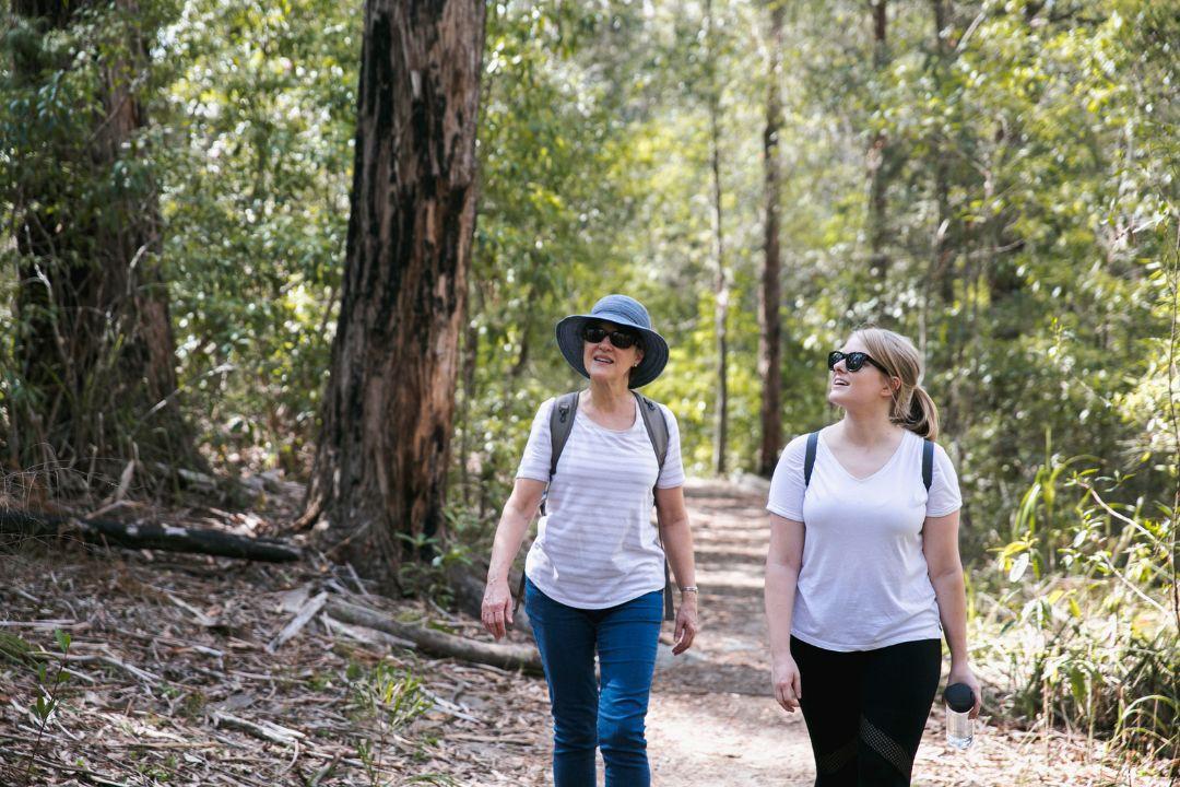 Two woman walking through bushland
