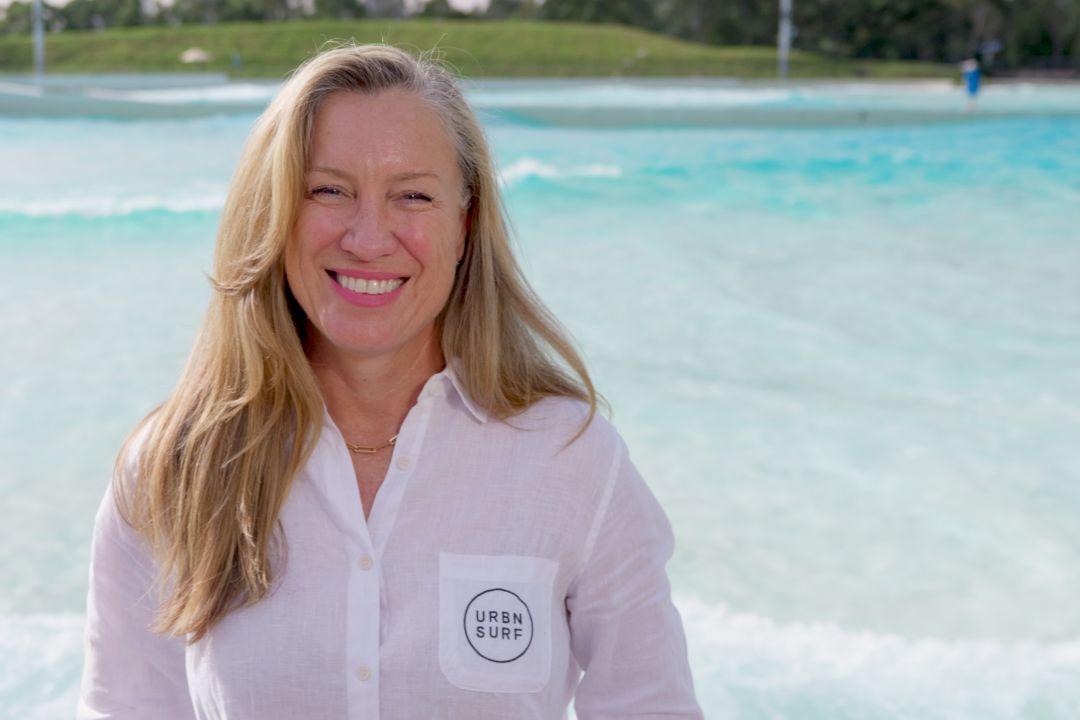 Blonde women in white shirt standing in front of large pool