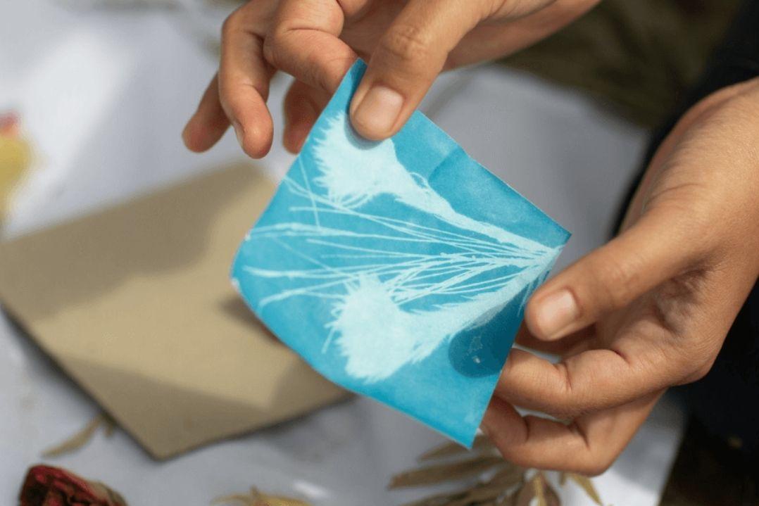 Hands hold a piece of blue celofan