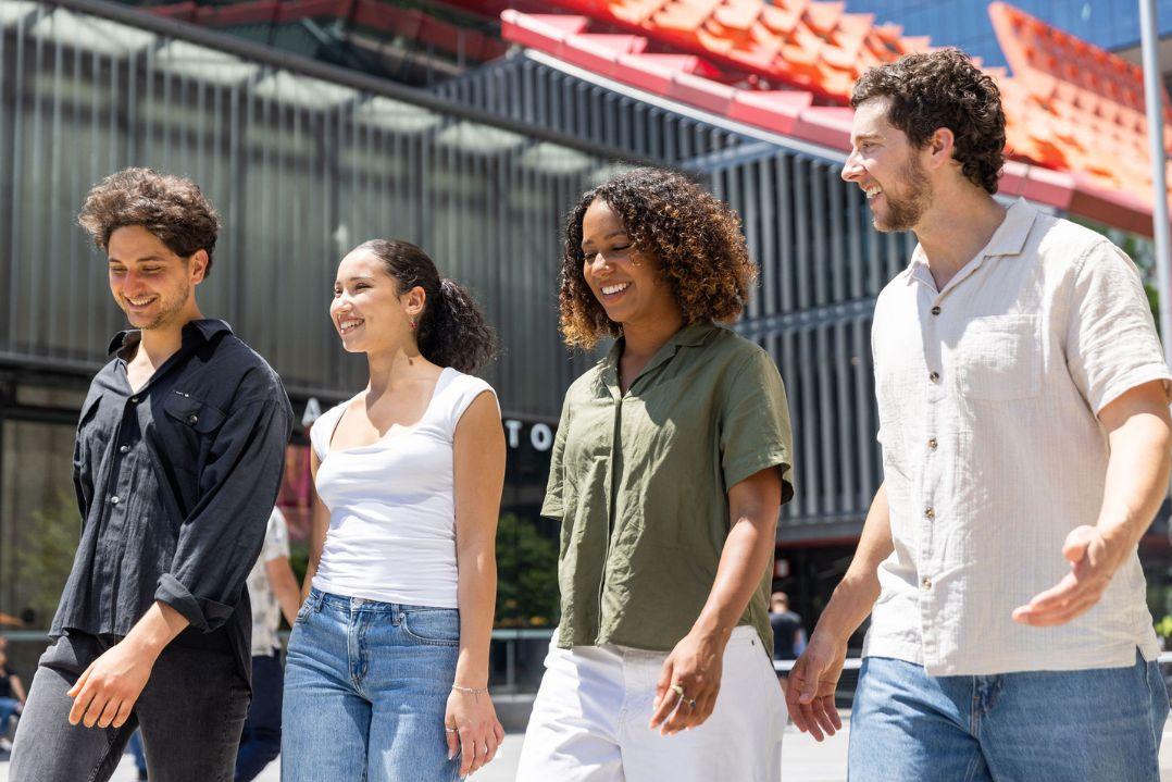 A group of 20 yers olds walking through the city laughing