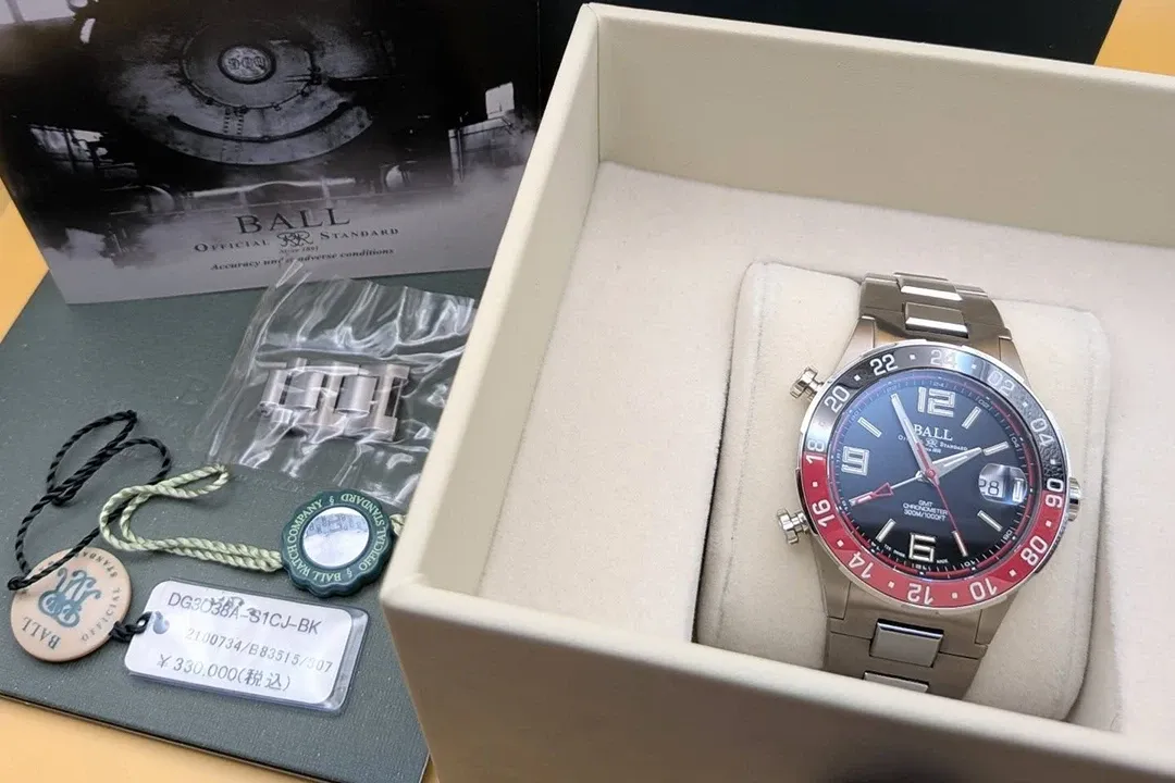 A close-up of a watch with a striking red and black face, nestled in a luxurious box.