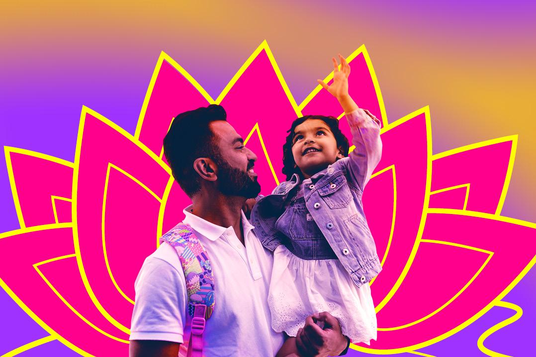 A bearded man holds a smiling child who reaches upward, framed by a vivid pink-and-yellow lotus graphic against a bright gradient background; joyful, celebratory mood.