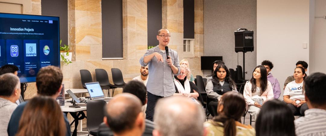 Presenter talking to a crowd of people at a workshop