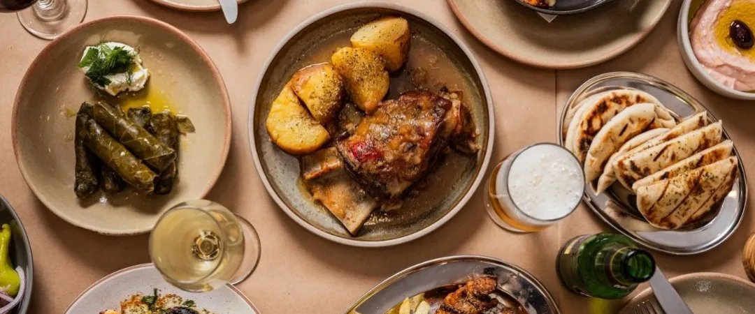 Table of grilled prawns, greek salad, chips