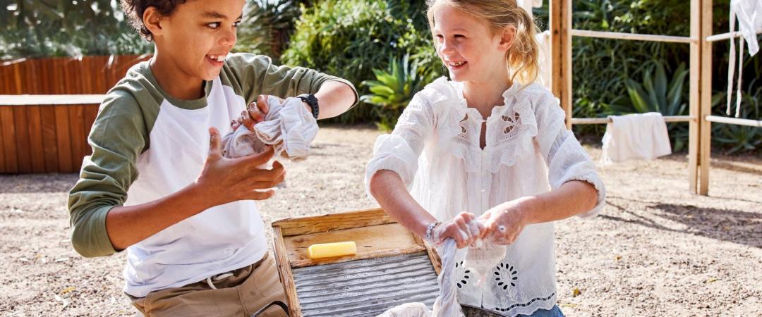 Kids playing outdoors with sand in their hands