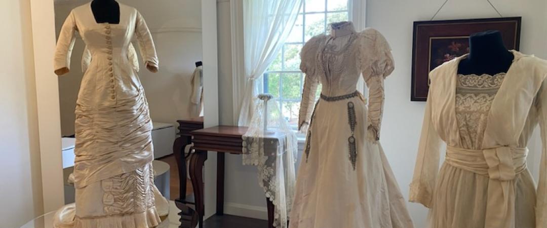 Room filled with fashionable dresses from the 1740s to 1960s era