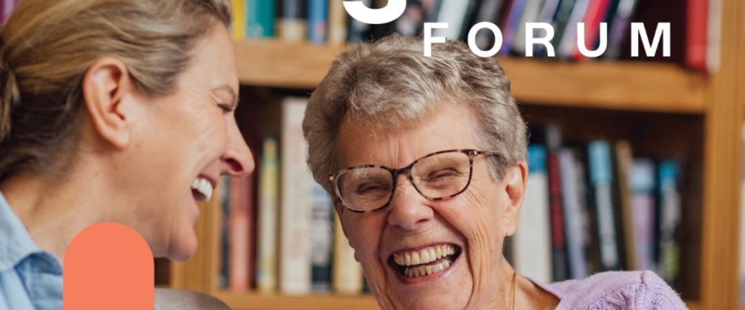 Two elderly women smiling at each other