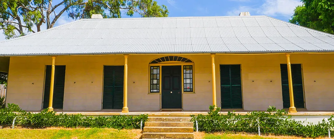 Experiment Farm cottage pictured from the front looking up the grand steps to the single level heritage home 
