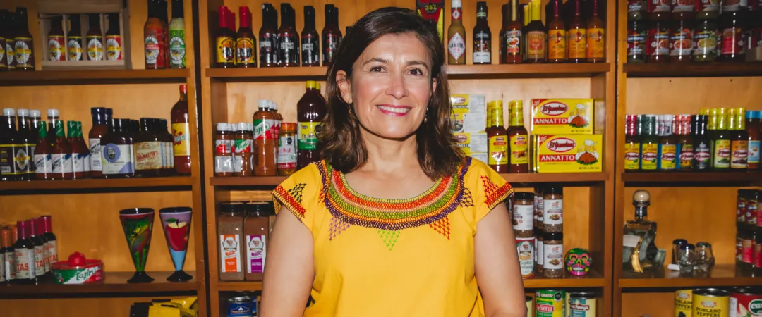 Women wearing yellow top standing in front of grocery shelves