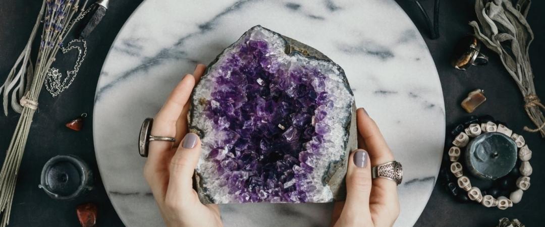 woman holding a large amethyst crystal in her hands