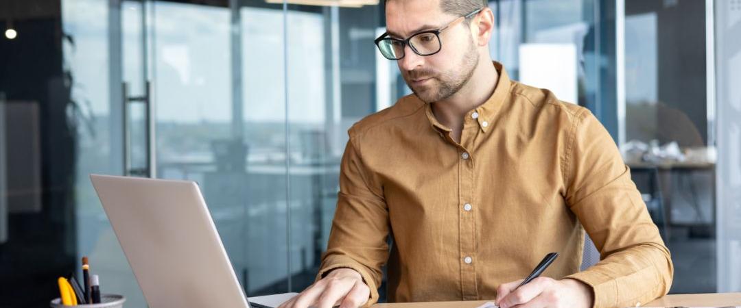 Man sitting at desk typing on computer