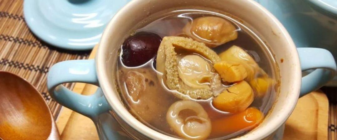 Large white bowl with hot liquid inside with meats and vegetable 