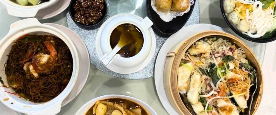 Bowls of food on a table like steamed rice with fish, soups & fishballs