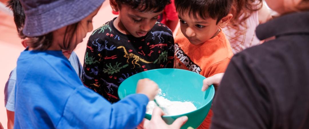 Three children mixing a teal bowl