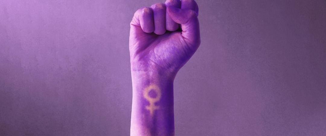 Hand forming a first covered in purple