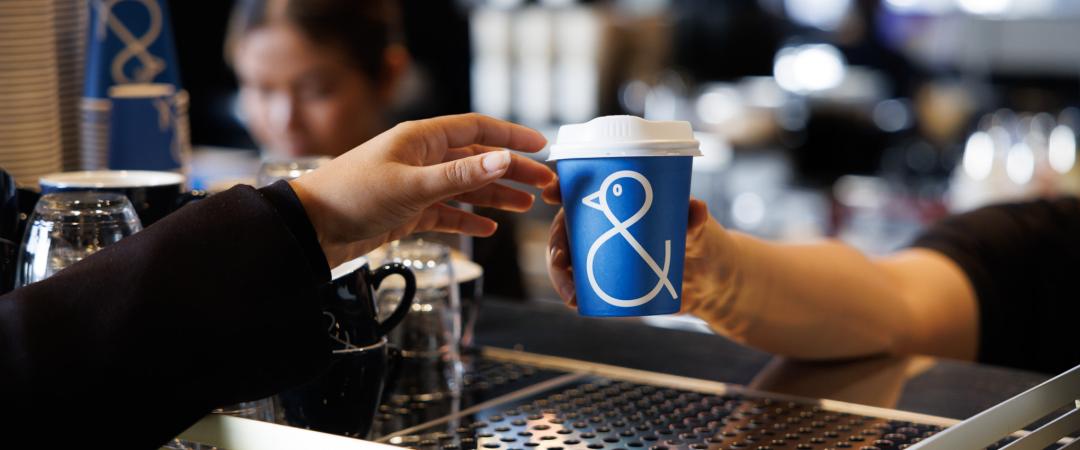 Barista giving a customer a cup of coffee