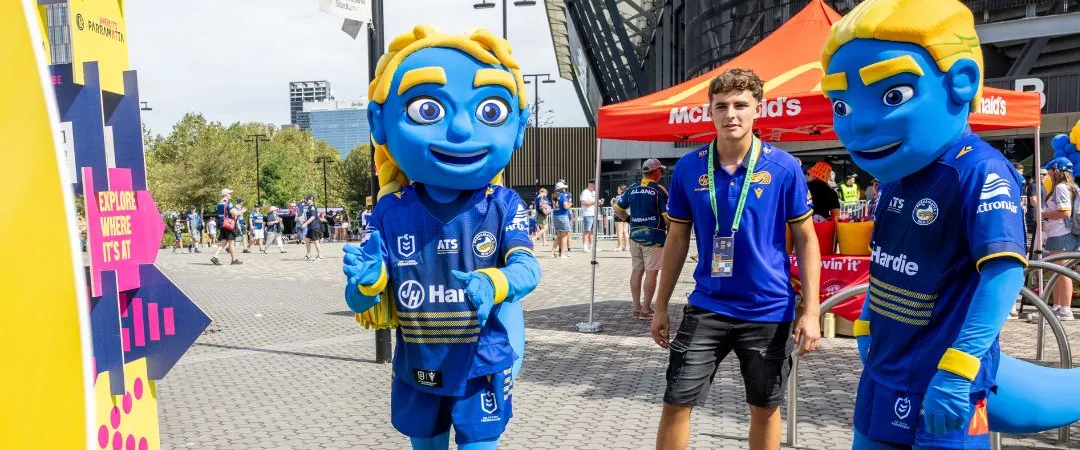 Blue male and female Parramatta mascots throwing a yellow football