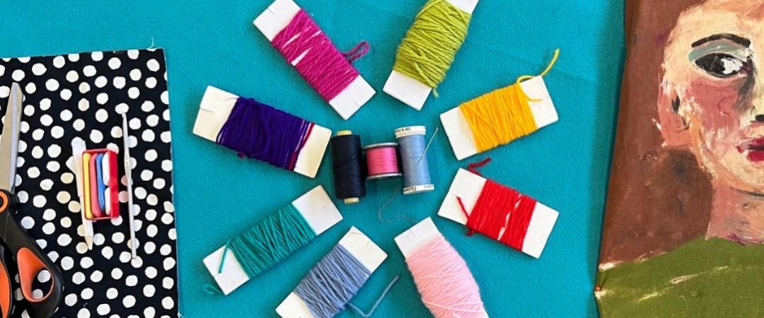 Sewing thread rolls against blue background