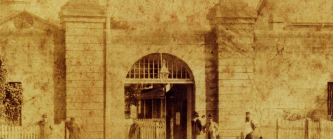 Black and white photo of people standing outside and old building
