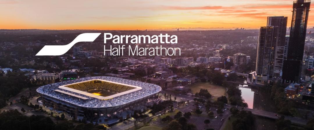 Aerial view of Parramatta at sunset, showcasing a stadium and skyscrapers near the Main River. Text reads "Parramatta Half Maraton," indicating corporate partnership.