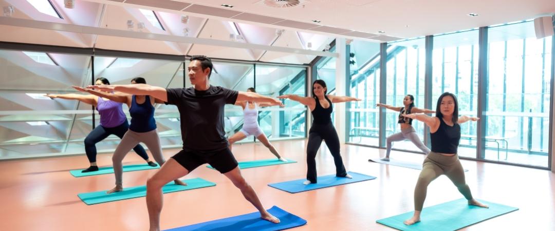 Group of people on yoga mats doing yoga stretches