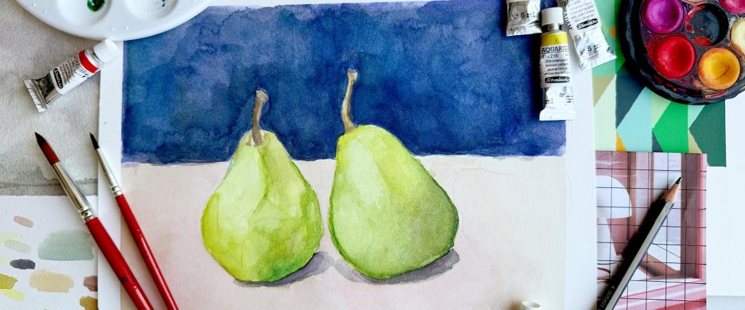 A watercolor painting of two green pears on a white surface with a dark blue background. Surrounding materials include brushes, paint tubes, and a palette.