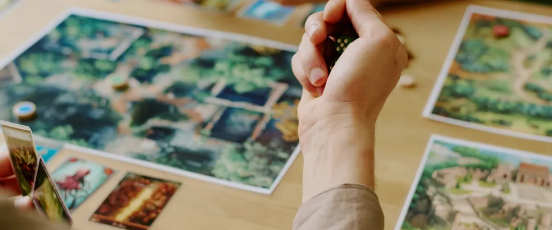 Hand holding pair of dice over table game