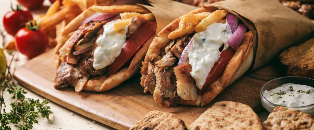 Greek souvlaki, gyros wrapped in pita breads on a wooden background
