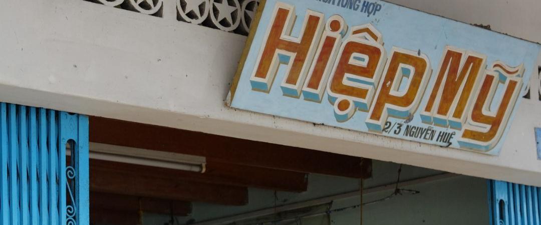Old concrete building with the sign in different letters and fonts
