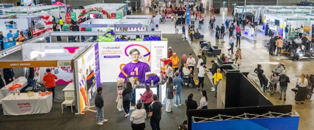 Exhibition Hall with stalls and women and men talking to stall about their products
