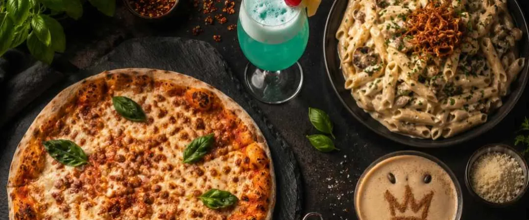 Tabe full of yummy plates of food like pizza, chips pasta and a blue drink