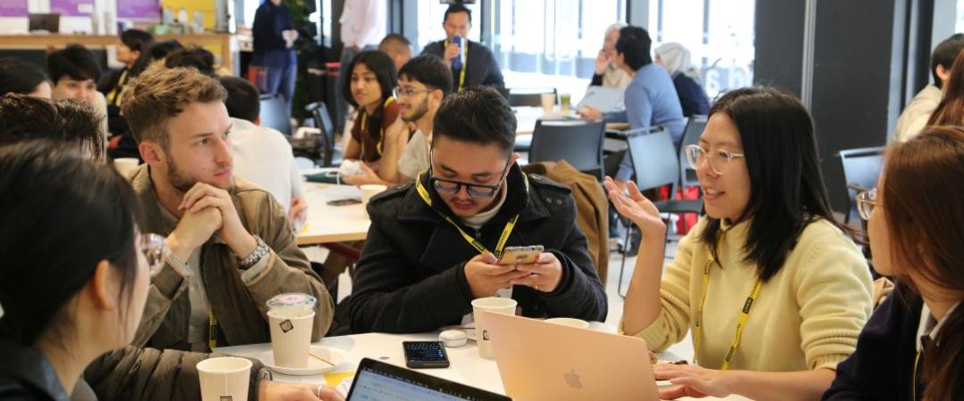 Group of people sitting at table with laptop