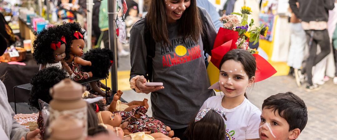Woman and children standing at market stall