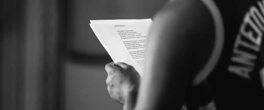 Black and white image of man holding sheets of paper