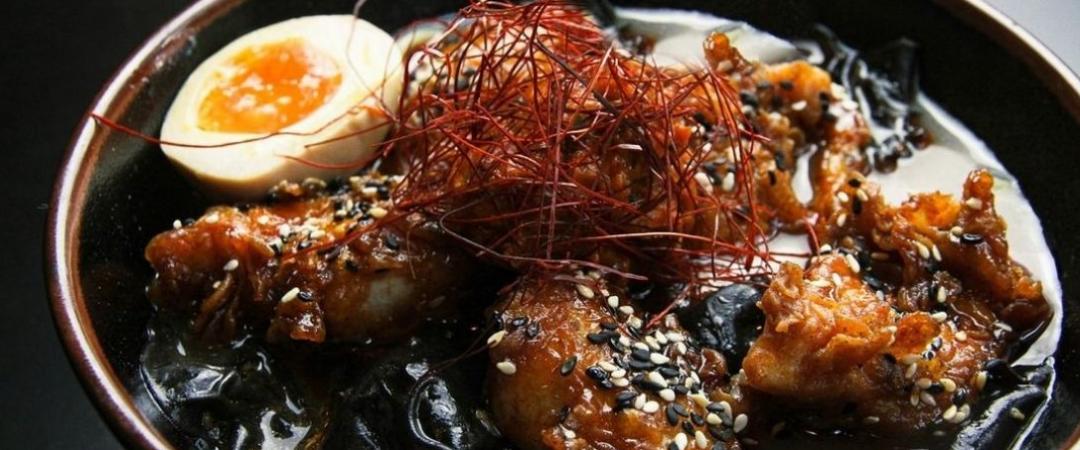 a bowl of ramen with butter fried chicken