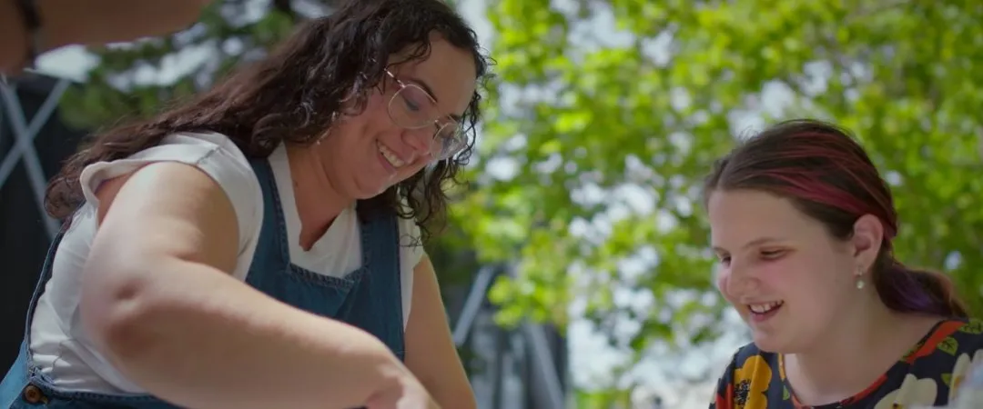 A woman and a young girl are gardening together at a table outdoors, surrounded by greenery. Both are smiling, conveying a joyful and collaborative atmosphere. The logo "futuretech" is visible in the corner.