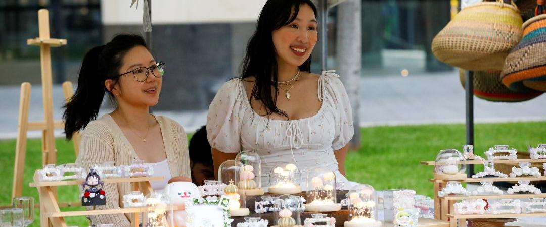 two women behind a table with accessories and gifts