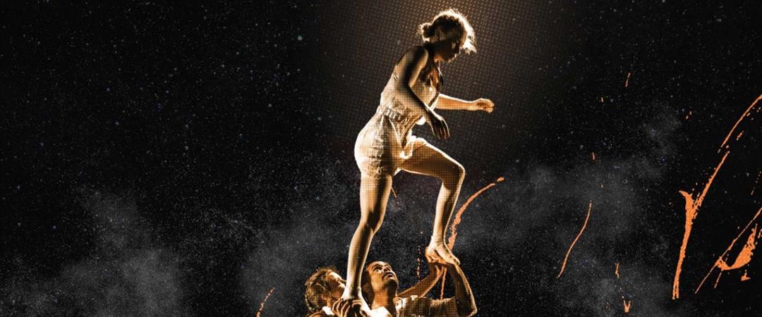 Two people are stacked on top of each other, suspended in the air, creating a unique and playful visual dynamic.