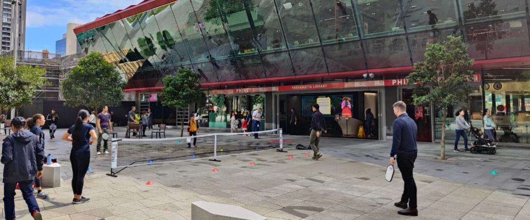 Men and women playing pickleball